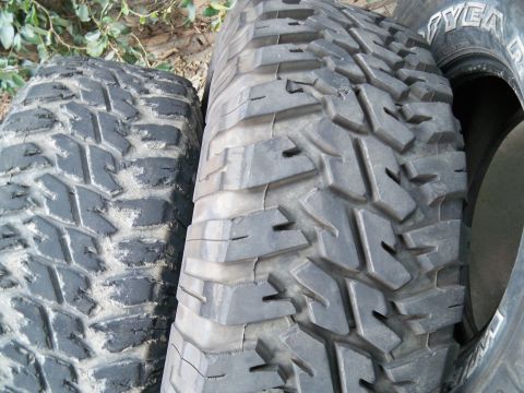 1985 Ford Bronco - Two off-road tires are shown, with one tire displaying the Goodyear brand name on its sidewall.