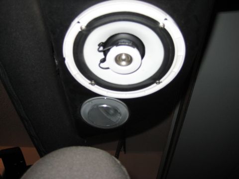 2005 Jeep Wrangler - Close-up of a white-cone coaxial speaker with an exposed tweeter mounted in the black cloth sound bar above the seat, with a round clear do…