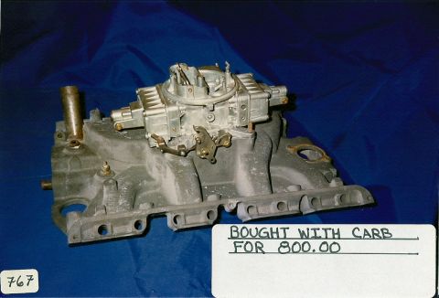 1973 Ford Mustang - A carburetor is mounted on an intake manifold, with a note indicating it was purchased with the carburetor for $800.00.