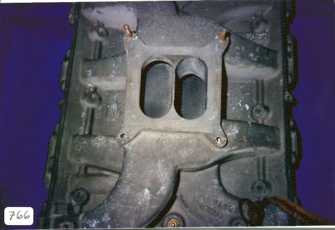 1973 Ford Mustang - Close-up view of an engine intake manifold, showing its dual carburetor ports and some casting marks.