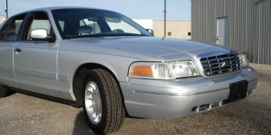 2000 Ford Crown Victoria - A silver 2000 Ford Crown Victoria is shown from the front quarter angle, parked outdoors.