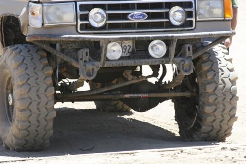 1989 Ford Bronco - This modified Ford Bronco features oversized tires and a custom front bumper, with a license plate visible.