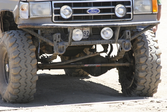 Front view of a modified Ford Bronco with large off-road tires, a custom bumper, and a license plate reading "192"