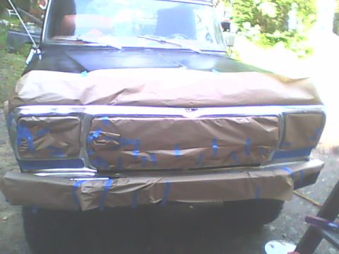 1978 Ford Bronco - This vehicle's front end is covered in masking paper and tape, indicating preparation for painting or repair work.