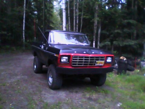 1978 Ford Bronco - This 1978 Ford F-Series truck features a distinctive red grille and is parked in a wooded area.