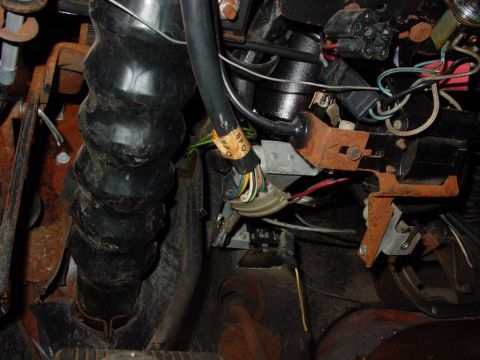 1968 Shelby GT500 - The wiring harness and rubber boot assembly under the steering column of a vehicle.