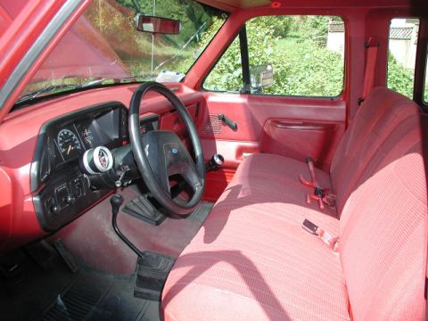 1990 Ford F-250 - Interior view of a red 1990 Ford F-250 pickup truck, showing the dashboard and seating.