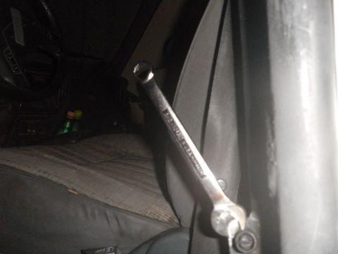 1991 Ford Bronco - A wrench is positioned inside the car's interior, near the door panel and seat.