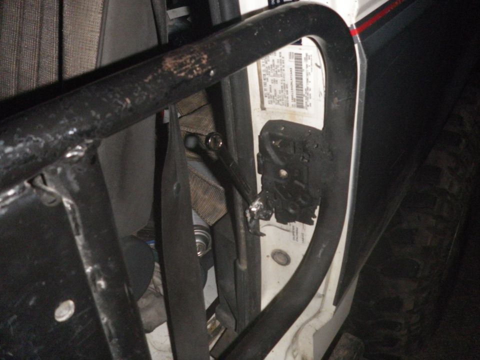 1991 Ford Bronco interior door frame with roll cage, seatbelt, and door latch mechanism