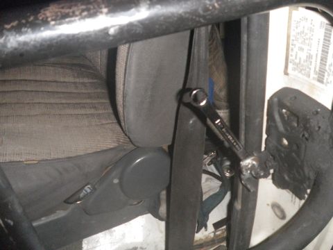 1991 Ford Bronco - A wrench is attached to the seatbelt buckle inside a vehicle's interior.