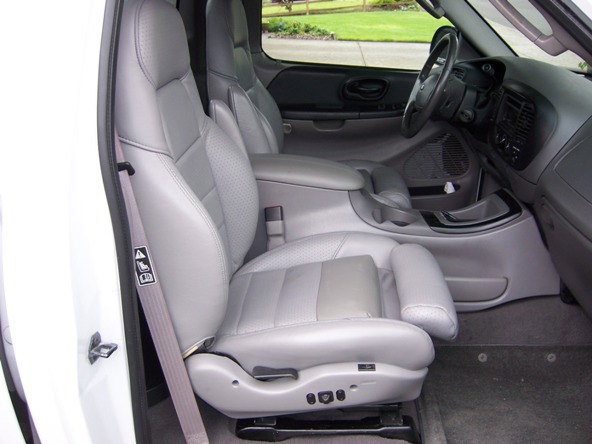 Gray leather bucket seats and center console of a truck