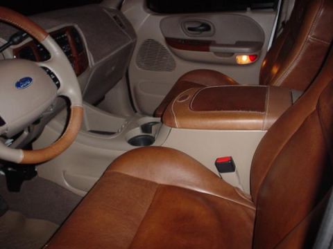 2007 Ford Mustang - The interior of a car with brown leather seats and a Ford steering wheel is visible.