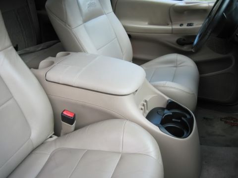 2007 Ford Mustang - Interior view of a vehicle's tan leather seats and center console with cup holders.