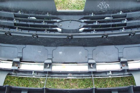 2006 Ford Fusion - Front grille and bumper section with horizontal slats and chrome trim. White writing on upper black plastic.