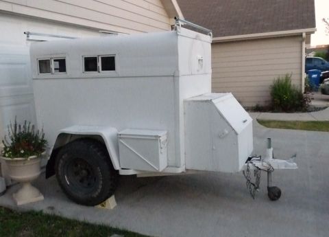 2006 Ford E350 - A white trailer is parked on a concrete driveway next to a house.