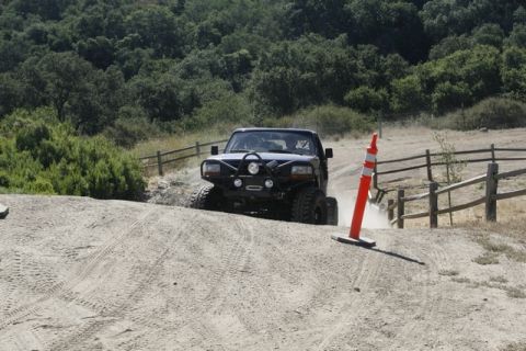 1989 Ford Bronco - Off-road driving scene with a 1989 Ford Bronco navigating a dusty track.