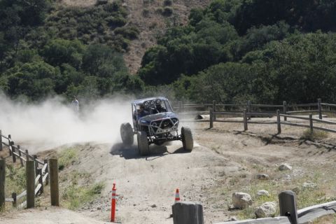1989 Ford Bronco - A custom off-road buggy navigates a dusty track during an event.