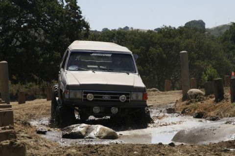 1989 Ford Bronco - This modified Ford Bronco navigates a muddy obstacle course, showing off its off-road capabilities.