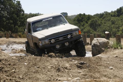 1989 Ford Bronco - This 1989 Ford Bronco navigates a challenging muddy terrain with large tires.