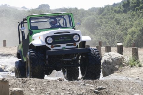 1989 Ford Bronco - This off-road vehicle navigates a muddy course with large tires and a distinctive grille.