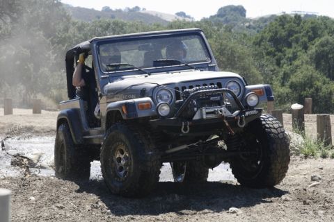 1989 Ford Bronco - This modified Jeep Wrangler Rubicon navigates a muddy off-road course.