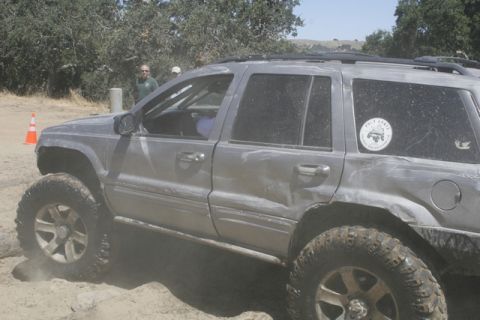 1989 Ford Bronco - This silver SUV is shown off-roading, kicking up dust on a dirt path.
