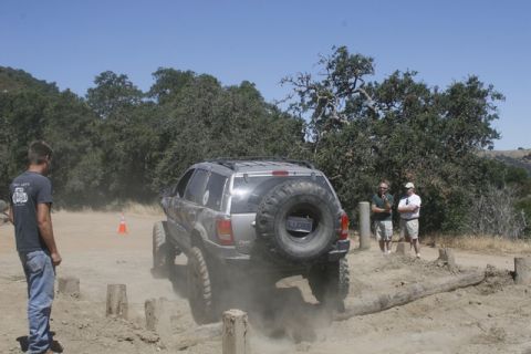 1989 Ford Bronco - A Jeep Grand Cherokee tackles a challenging off-road course, demonstrating its capabilities on rough terrain.