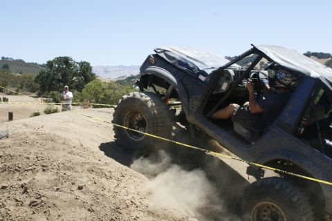 1989 Ford Bronco - This modified off-road vehicle navigates a challenging dirt obstacle during an event.