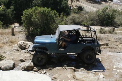1989 Ford Bronco - This Jeep CJ-5 is shown off-roading through a challenging rocky and watery path.