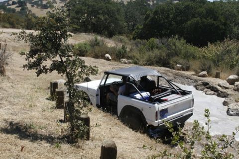 1989 Ford Bronco - This 1989 Ford Bronco is navigating a challenging off-road course with a soft top and roll cage.