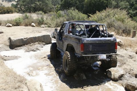 1989 Ford Bronco - This modified Bronco navigates a challenging off-road course with large tires and a protective roll cage.