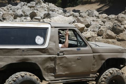 1989 Ford Bronco - This heavily modified 1989 Ford Bronco navigates a rocky terrain, showing off its off-road capabilities and battle scars.