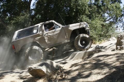 1989 Ford Bronco - A modified Ford Bronco navigates a challenging off-road course, demonstrating its capabilities.