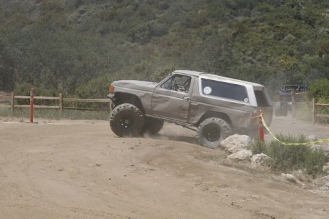1989 Ford Bronco - This lifted SUV navigates a rocky off-road course, demonstrating its capabilities.