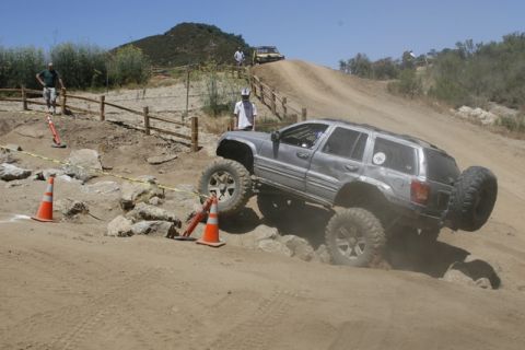 1989 Ford Bronco - An off-road SUV tackles a challenging course with steep inclines and rocky obstacles.
