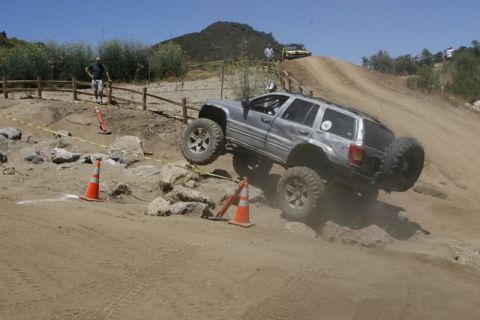 1989 Ford Bronco - Modified Jeep Grand Cherokee navigates a challenging off-road obstacle course.