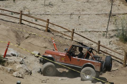 1989 Ford Bronco - An off-road vehicle tackles a challenging course with caution tape and orange cones marking the path.