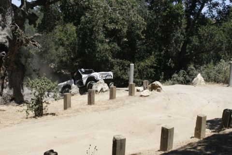 1989 Ford Bronco - This 1980s Ford Bronco navigates a dusty, off-road course with a rocky, wooded backdrop.