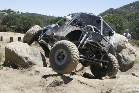 1989 Ford Bronco - A custom-built off-road buggy navigates a challenging rocky terrain.