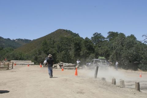1989 Ford Bronco - An off-road buggy navigates a dusty course during an event, with spectators and natural scenery visible.