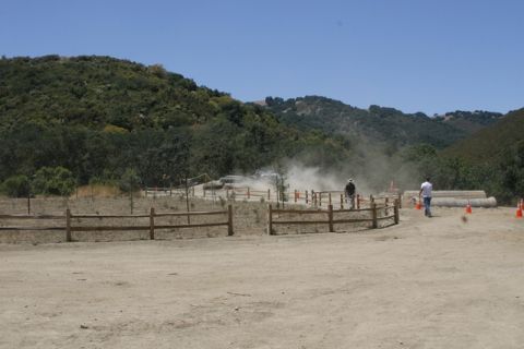 1989 Ford Bronco - An off-road vehicle navigates a dusty course during an event, with onlookers observing the action.