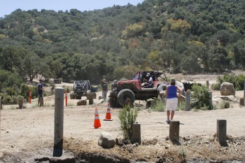 1989 Ford Bronco - Off-road vehicles navigate a challenging dirt course with spectators watching the event.