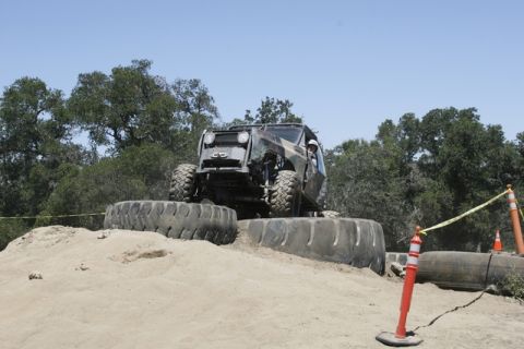 1989 Ford Bronco - A custom off-road vehicle navigates an obstacle course made of large tires.