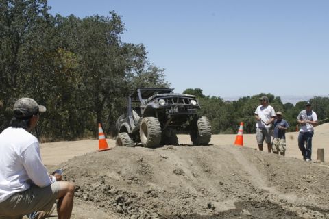 1989 Ford Bronco - An off-road vehicle navigates a challenging dirt obstacle during an event.