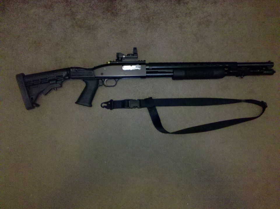 Pump-action shotgun with red-dot sight, pistol grip and sling on beige carpet