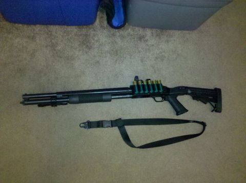2001 Ford F-150 - A shotgun with a tactical stock and a sling is displayed on a carpeted surface.