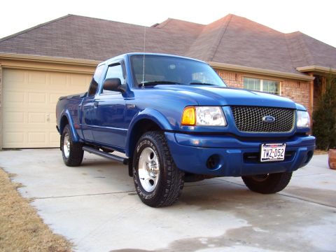 2001 Ford Ranger - A blue Ford Ranger pickup truck is parked in front of a residential garage.