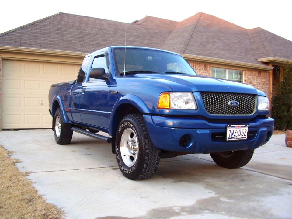 Blue Ford Ranger pickup truck parked in driveway in front of a house