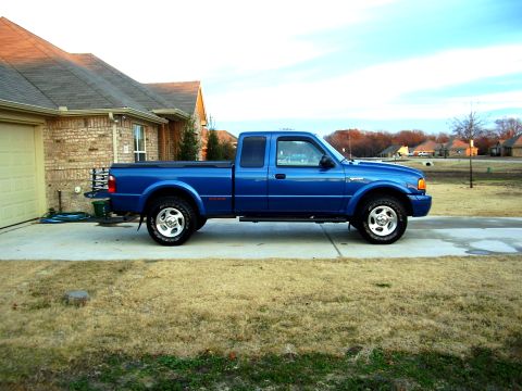2001 Ford Ranger - A blue 2001 Ford Ranger pickup truck is parked on a concrete driveway in front of a brick house.