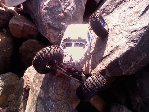 1996 Ford Bronco - A remote control rock crawler navigates a challenging rocky terrain on a sunny day.